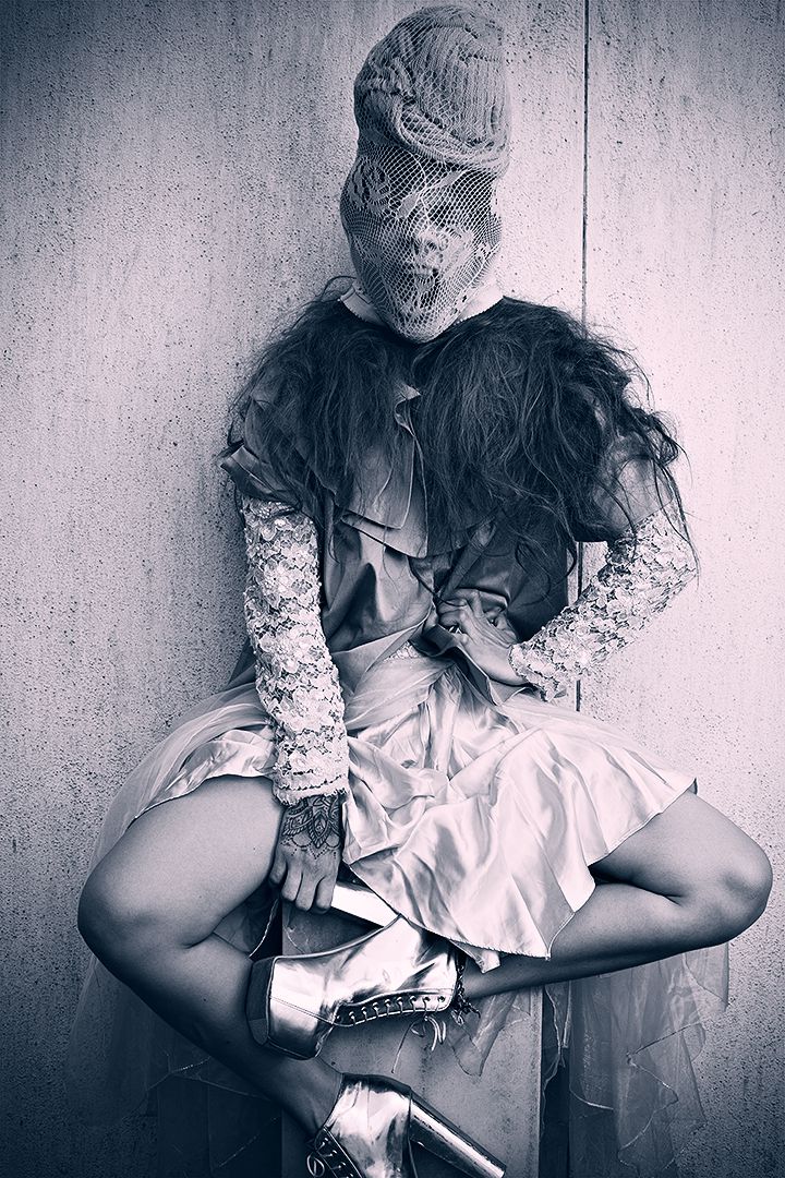 Conceptual editorial with lace face covering and deconstructed layered dress, desaturated blue tones